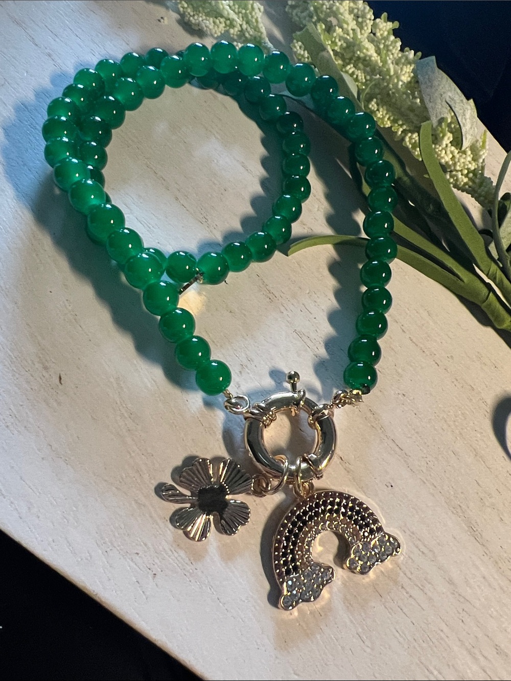Plunder green bead necklace with rainbow and clover charms on carabiner